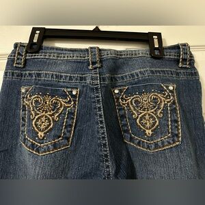 Boot cut blue jeans with embellished back pockets. Size 12.